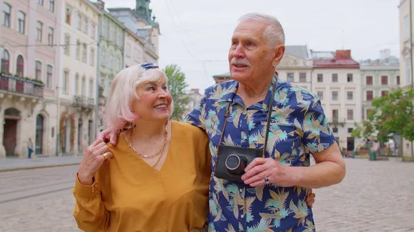 Senior oude stijlvolle toeristen man, vrouw, grootmoeder, grootvader familie met een wandeling in de zomer stad — Stockfoto