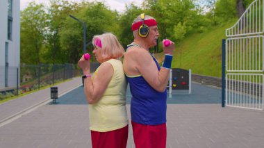 Aktif yaşlı spor takımı. Büyükannem, büyükbabam halter kaldırıyor, kameraya gülümsüyor.