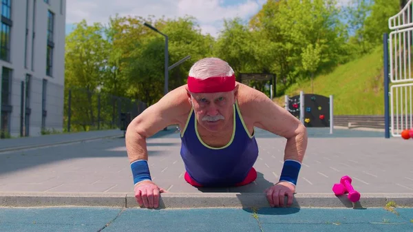 Homem sênior avô 80 anos fazendo esporte cardio treinamento push-ups exercitando no parque infantil — Fotografia de Stock