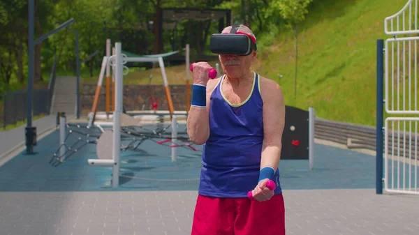 VR kulaklıklı yaşlı adam halterle ağırlık kaldırma egzersizi yapıyor.