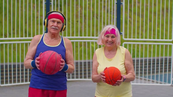 Старший баскетбольний спорт пара чоловік жінка грає в гру в м'яч, практикуючи дриблінг на стадіоні корт — стокове фото