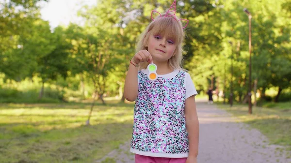 Snygg barn flicka spelar färgglada squishy silikon bubblor sensorisk leksak enkel dimple pop det spel — Stockfoto