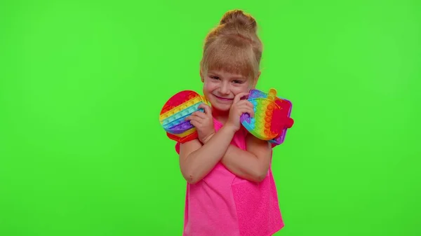 Menina criança segurando muitas bolhas de silicone squishy coloridas pop-lo brinquedos sensoriais populares, polegar para cima — Fotografia de Stock
