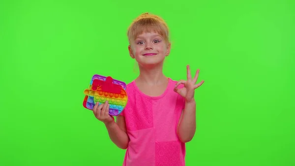 Menina criança segurando muitas bolhas de silicone squishy coloridas pop-lo brinquedos sensoriais populares, polegar para cima — Fotografia de Stock