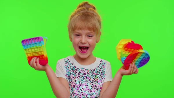 Дети девочка ребенок держа сжимая анти-стресс сенсорный экран нажмите поп это популярная игрушка на хрома ключ — стоковое фото