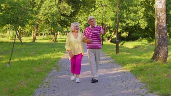 Старшие стильные пенсионеры пара бабушка дедушка ходить, наслаждаясь время вместе в парке — стоковое фото