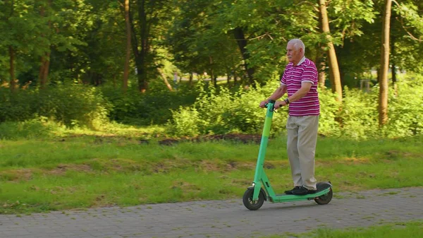 Son sınıf stil sahibi büyükbaba emeklilikten sonra parkta elektrikli scooter kullanan turist. — Stok fotoğraf