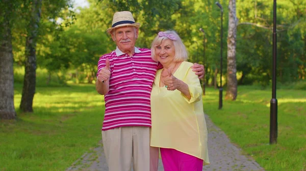 Старшая стильная пара бабушка дедушка выглядит одобрительно показывая большой палец вверх, как знак жеста — стоковое фото