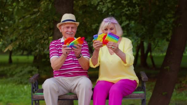 Senior nonno elegante nonna mostrando spremendo anti-stress spingere pop è popolare gioco giocattolo — Video Stock