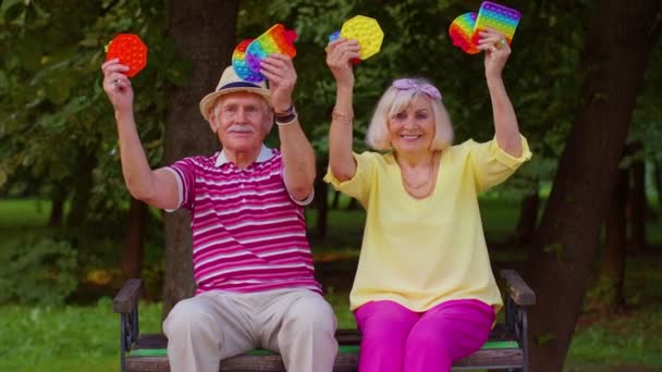 Grand-père sénior élégant tenant serrant jouet anti-stress jeux de fossettes simples dans le parc — Video