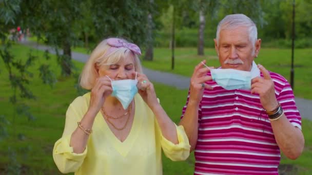 Starsza babcia i dziadek noszący medyczną maskę ochronną w parku podczas koronawirusu — Wideo stockowe