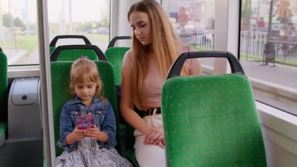 Fáradt álmos nő lánya megy haza busszal kemény munka után nap, gyerek játszani okostelefon — Stock videók
