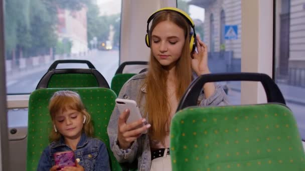 Dziewczynka z matką za pomocą smartfona ze słuchawkami, słuchawki słuchanie muzyki, zabawny taniec — Wideo stockowe
