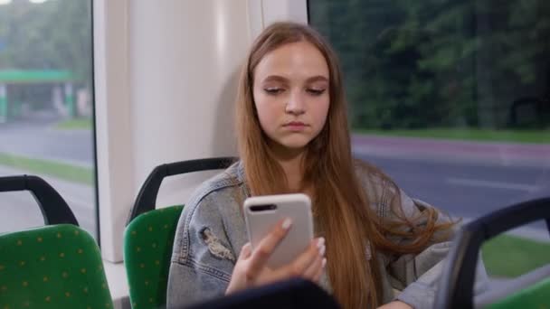 Mujer jugando en el teléfono inteligente, chatear, mensajes de texto, navegar por las redes sociales mientras viaja en autobús a la ciudad — Vídeo de stock