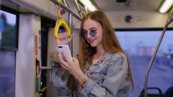 Mujer jugando en el teléfono inteligente, chatear, mensajes de texto, navegar por las redes sociales mientras viaja en autobús a la ciudad — Vídeo de stock