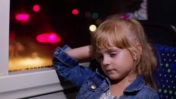 Tired, bored little child girl sitting alone in bus transport after hard study day and falls asleep — Stock Video