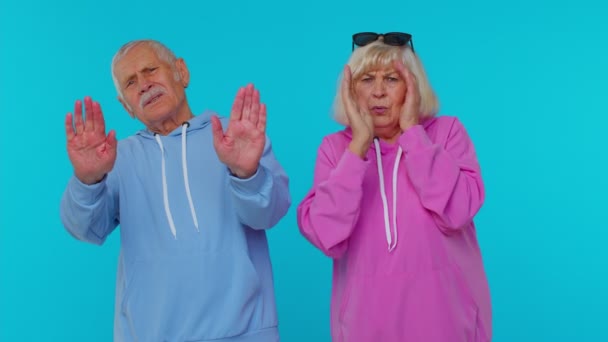 Senior stylowe dziadkowie zamykając oczy z ręki pokazując stop gest mylić nieśmiały boi się patrzeć — Wideo stockowe