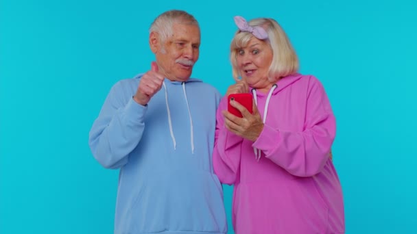 Heureux couple homme femme grand-parents utilisent téléphone mobile célébrant découvert de grandes nouvelles grande victoire — Video