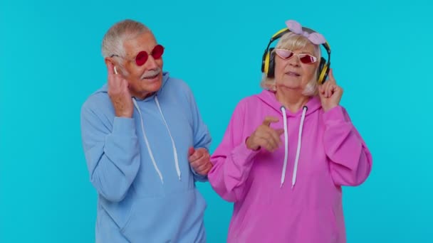 Grands-parents aînés élégants pensionnés écoutant de la musique via un casque, dansant disco s'amuser autour — Video