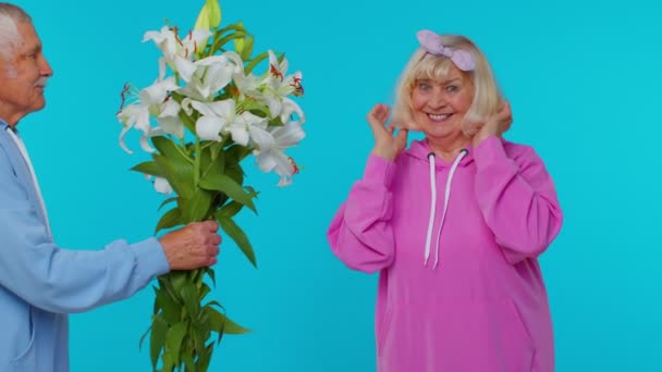 Старший дід подарував бабусі букет квітів, щаслива зріла сім'я на пенсії в старості — стокове відео