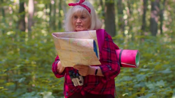 Senior gammal turist mormor kvinna förlorade och titta på kartan samtidigt som du har gått i trä utomhus — Stockvideo