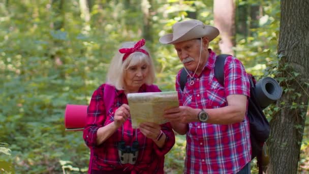 Senior donna uomo sposato perso in legno, alla ricerca di modo indietro, turisti guardando la mappa durante le escursioni — Video Stock