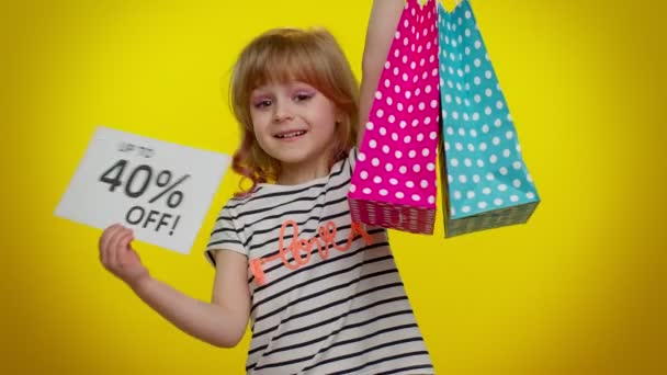 Niño niña mostrando bolsas de compras y hasta 40 por ciento de descuento inscripciones pancarta de texto, Viernes Negro — Vídeos de Stock