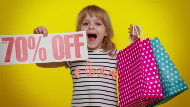 Παιδί κοριτσάκι δείχνει τσάντες ψώνια και μέχρι 70 τοις εκατό Off επιγραφές banner κείμενο, Μαύρη Παρασκευή — Αρχείο Βίντεο