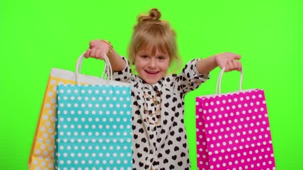 Kid meisje tonen boodschappentassen, reclame kortingen, lage prijzen, winkelen op Black Friday vakantie — Stockvideo