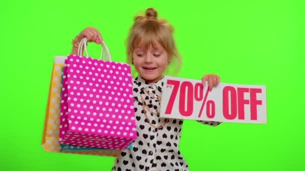 Alışveriş torbalarını gösteren kız çocuğu ve% 70 'e yakın indirimli yazı, Kara Cuma — Stok video