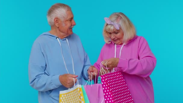 Grands-parents âgés matures montrant des sacs à provisions, la publicité des rabais à bas prix, Black Friday vente — Video