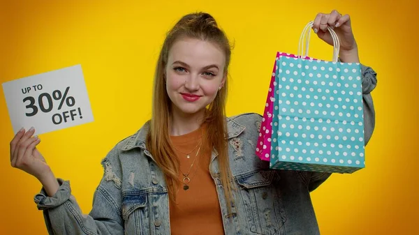 Fröhliches Teenie-Mädchen zeigt Einkaufstüten und bis zu 30 Prozent Rabatt auf Aufschriften Banner, Black Friday — Stockfoto