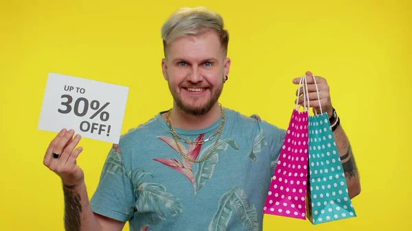 Χαρούμενος τουρίστας δείχνει τσάντες ψώνια και μέχρι 30 τοις εκατό Off επιγραφές banner Μαύρη Παρασκευή — Φωτογραφία Αρχείου