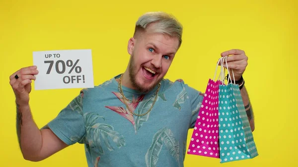 Χαρούμενος τουρίστας δείχνει τσάντες ψώνια και μέχρι 70 τοις εκατό Off επιγραφές banner Μαύρη Παρασκευή — Φωτογραφία Αρχείου