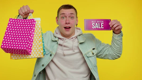 Glückliche Student Mann zeigt Verkauf Beschriftung Banner Text, Werbung Rabatte niedrige Urlaubspreise — Stockfoto