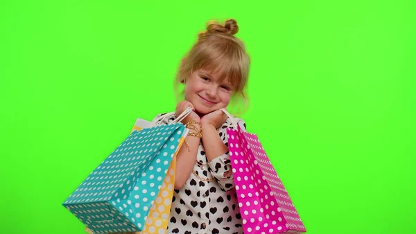 Kid girl mostrando sacos de compras, descontos de publicidade, preços baixos, compras em Black Friday feriados — Fotografia de Stock