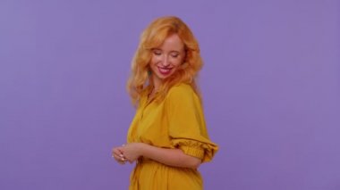 Neşeli, uzun saçlı, güzel, güzel bir kız. Sarı elbiseli, gülümseyen ve kameraya bakan bir model.