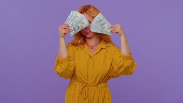 Dumny arogancki bogaty stylowy dziewczyna trzyma pieniądze gotówką w dolarach banknotów, uśmiechnięty, patrząc w aparat — Wideo stockowe