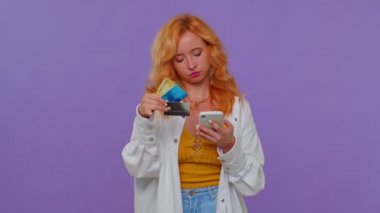 Para transfer ederken kredi kartı ve akıllı telefon kullanan kız, online alışveriş yapıyor.