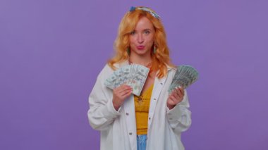 Gururlu, zengin, şık bir kız elinde para, banknotlar, gülümseyen, kameraya bakan.