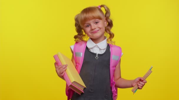 Veselý legrační školačka kluk s knihami oblečený v uniformě nosí batoh s úsměvem na kameru — Stock video