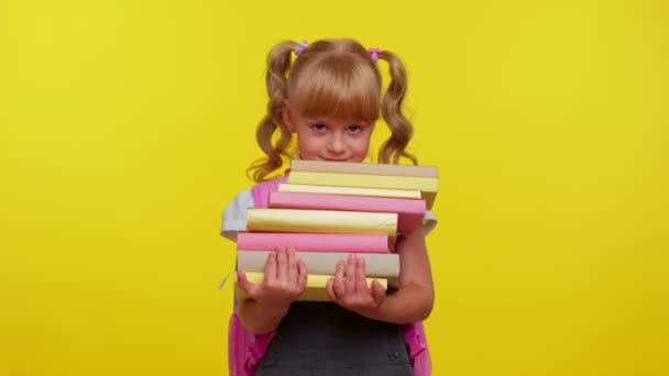 Cansado nerdn escolar niña usar mochila celebración pila de libros, parece agotado, triste de la tarea — Vídeos de Stock