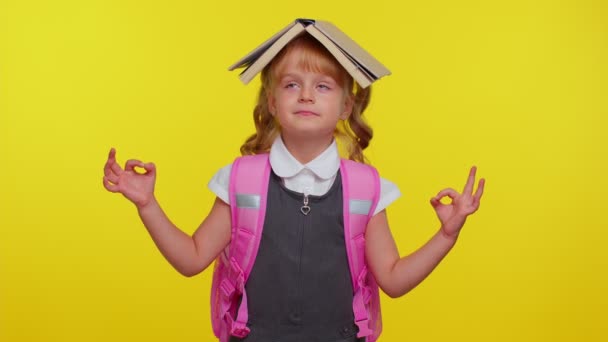 Teenage girl in school uniform putting book on head, meditating, relaxing with concentrated thoughts — Stock Video