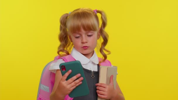 Menina criança em uniforme escolar usando telefone celular digitando novo post, mensagem sms, navegação redes sociais — Vídeo de Stock