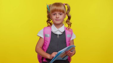 Atkuyruklu, üniformalı, sarı arka planda gülümseyen komik, pozitif bir ilkokul çocuğu.