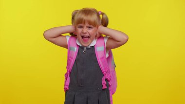 Sinirli, sinirli, okul üniformalı, kulaklarını kapatan, hayır diyen, tavsiyeden kaçan bir kız.