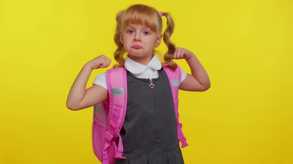 Krásné sebevědomé dítě dívka ve školní uniformě ukazující biceps, pocit síly pro studium — Stock fotografie