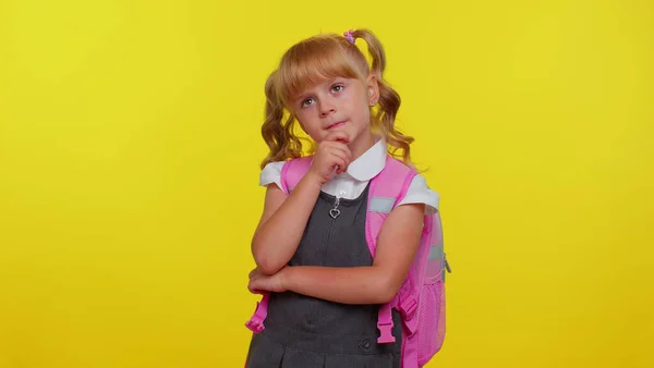 Pensativo inteligente bonito menina no uniforme da escola esfregando queixo ponderando uma solução dúvida questão — Fotografia de Stock