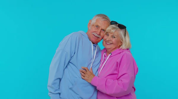 Romantyczny starszy para dziadek babcia przytula, przytula, patrząc w aparat i uśmiechając — Zdjęcie stockowe
