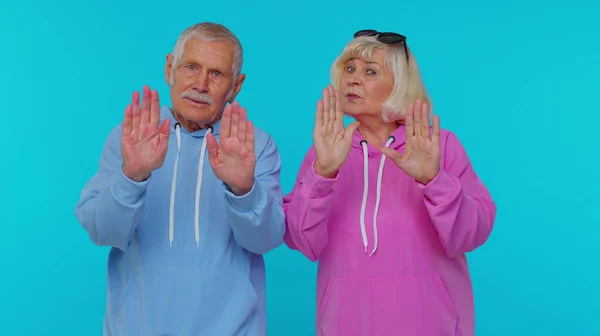 Anziano nonno anziano nonna dire no tenere le mani incrociate palmo della mano in stop gesto, avvertimento — Foto Stock